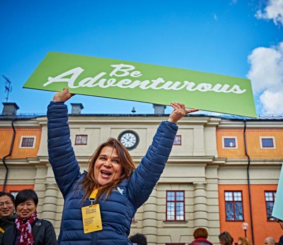 Woman displaying a be adventurous banner 